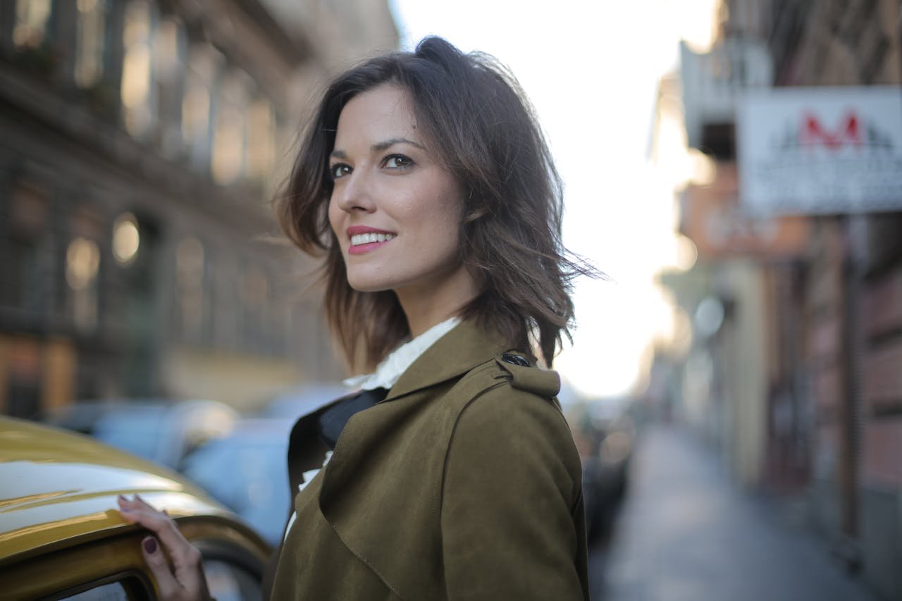 Woman in Green Coat  Standing Near Yellow Cab